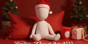 Muñeco de algodón sin rostro con gorro de navidad y con un mensaje navideño. Feliz navidad.