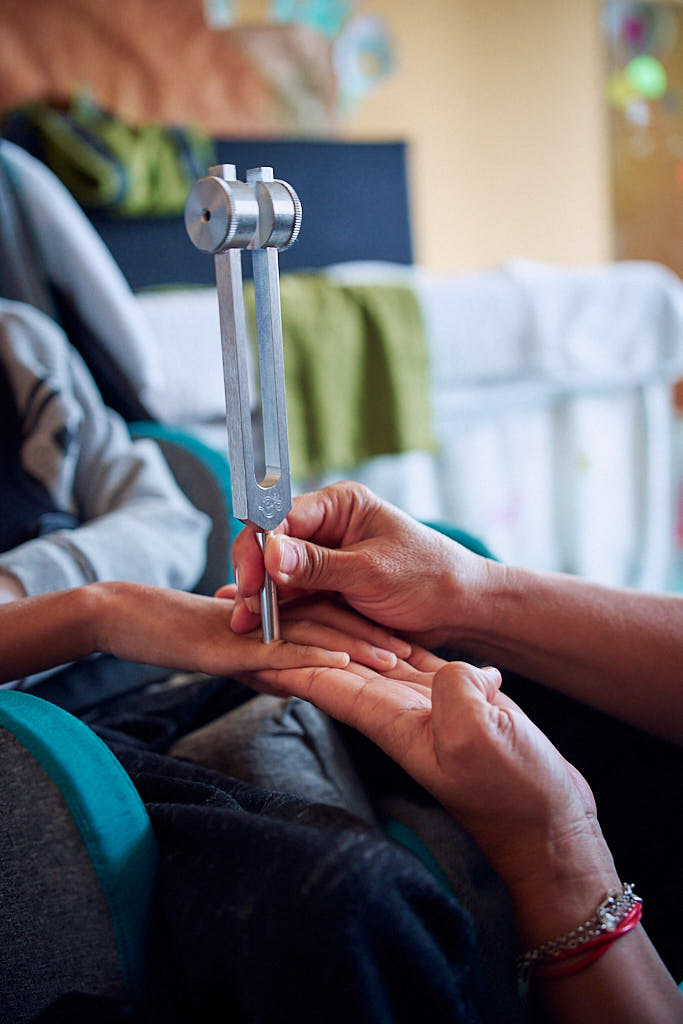 Diapasón vibrando en la mano de un niño que presenta parálisis cerebral