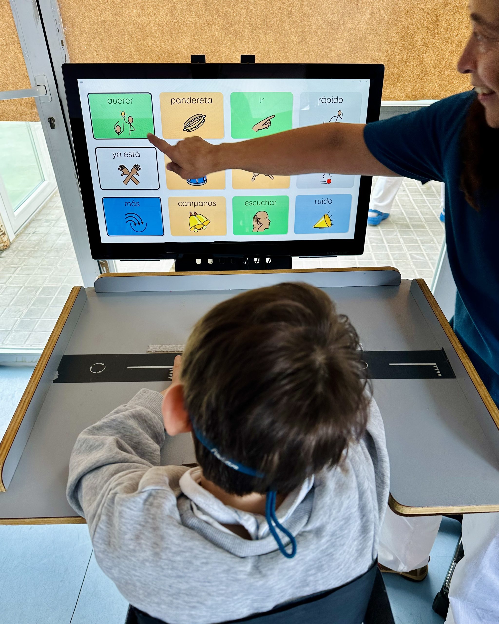 Niño en bipedestador utilizando un programa de comunicación alternativo