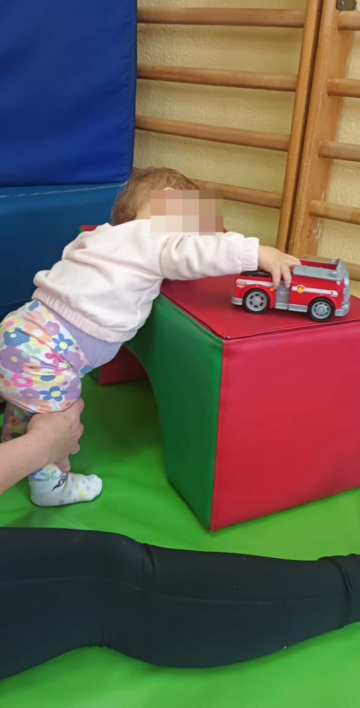 Personal de apoyo anima al juego en aula de fisioterapia