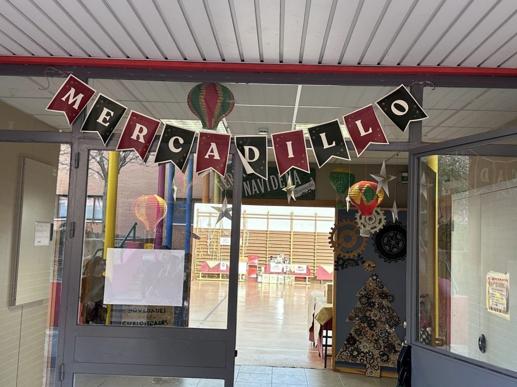 Entrada al mercadillo con una guirnalda de banderines «Mercadillo»