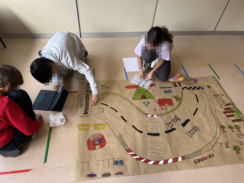 Alumnos/as programan un recorrido sobre un gran circuito dibujado en el suelo controlado con una tablet