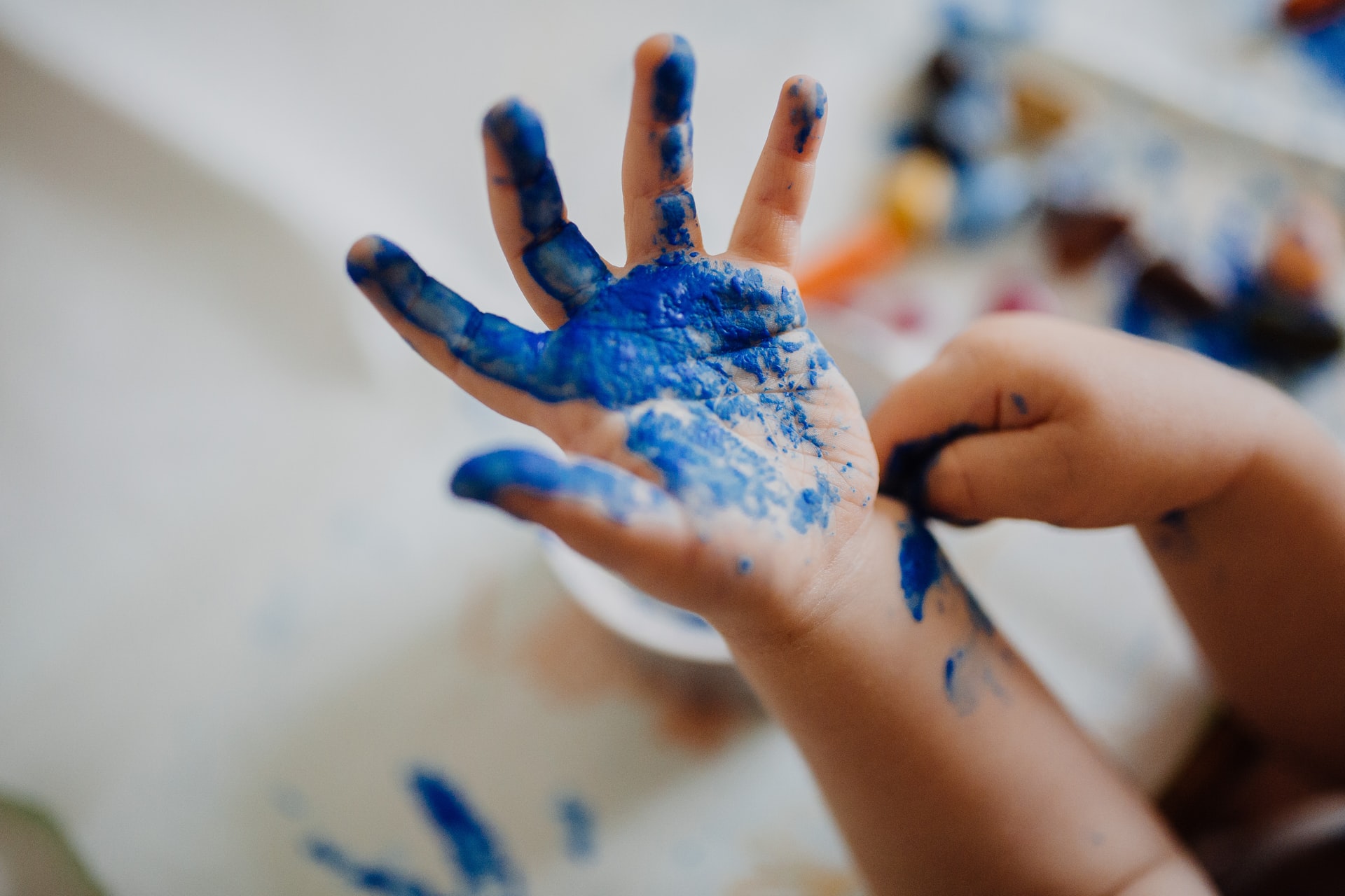 una mano de niño pintada con pintura azul