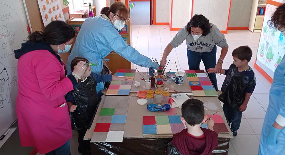 Haciendo un mosaico con azulejos para decorar el patio. CEIP Navahonda.