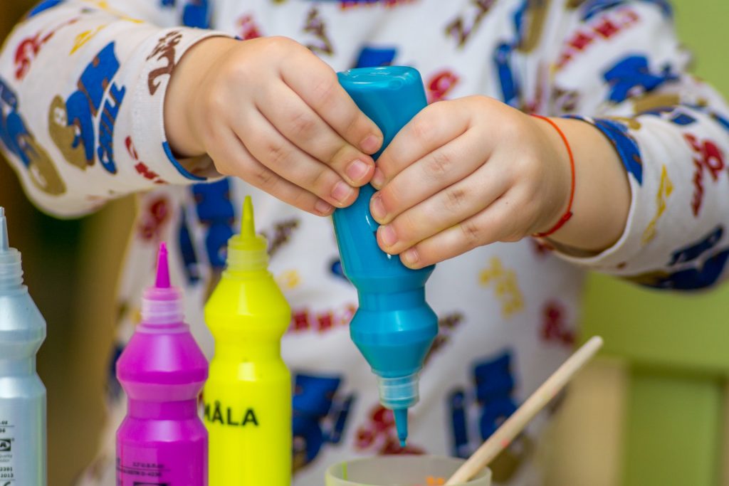 Niño pequeño utilizando botes de pintura.