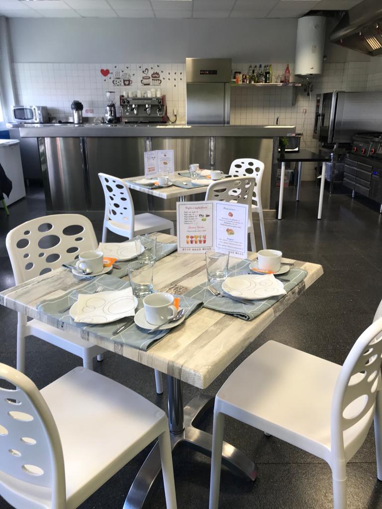 Imagen de la cafetería con las mesas preparadas