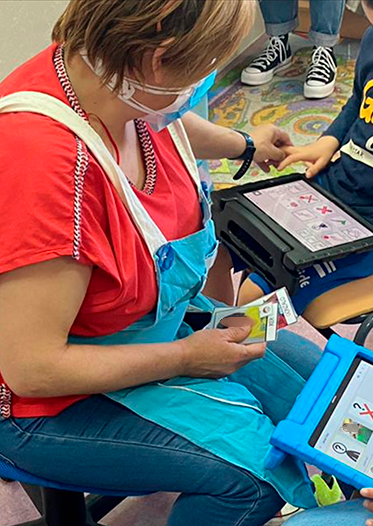Especialista en Audición y Lenguaje trabajando con alumnos y tablets
