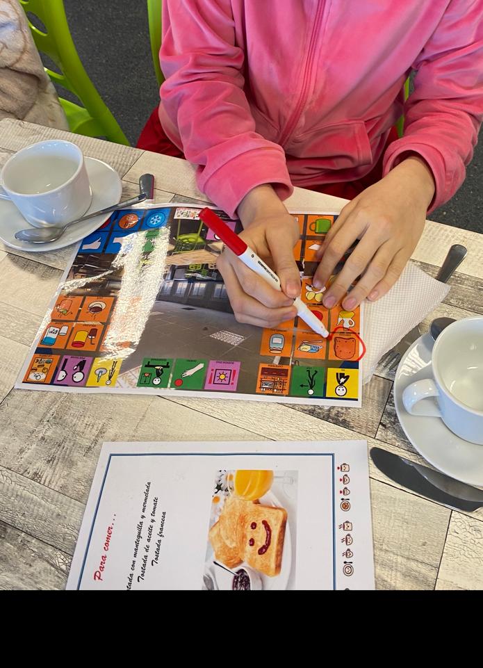 IMAGEN DE ALUMNA ELIGIENDO DESAYUNO CON SALVAMANTELES