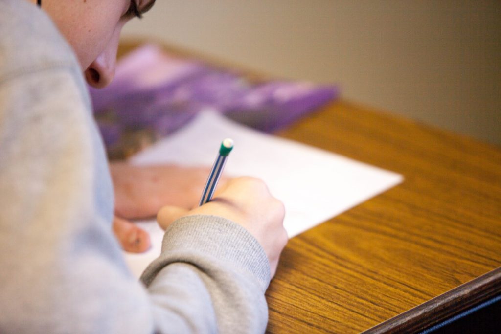 alumno escribiendo sobre papel en el escritorio