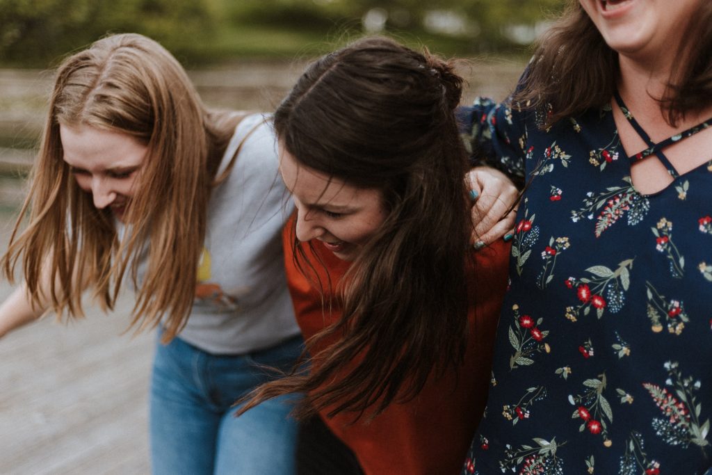 tres chicas abrazándose y sonriendo