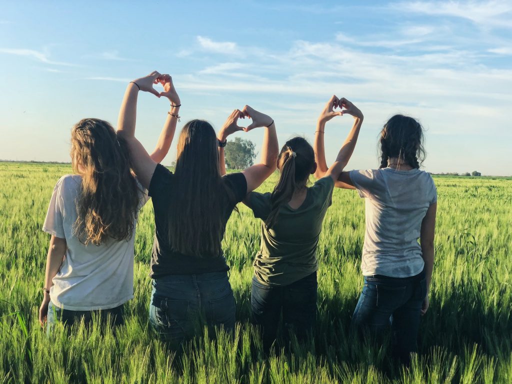 cuatro chicas haciendo formas de corazón con las manos