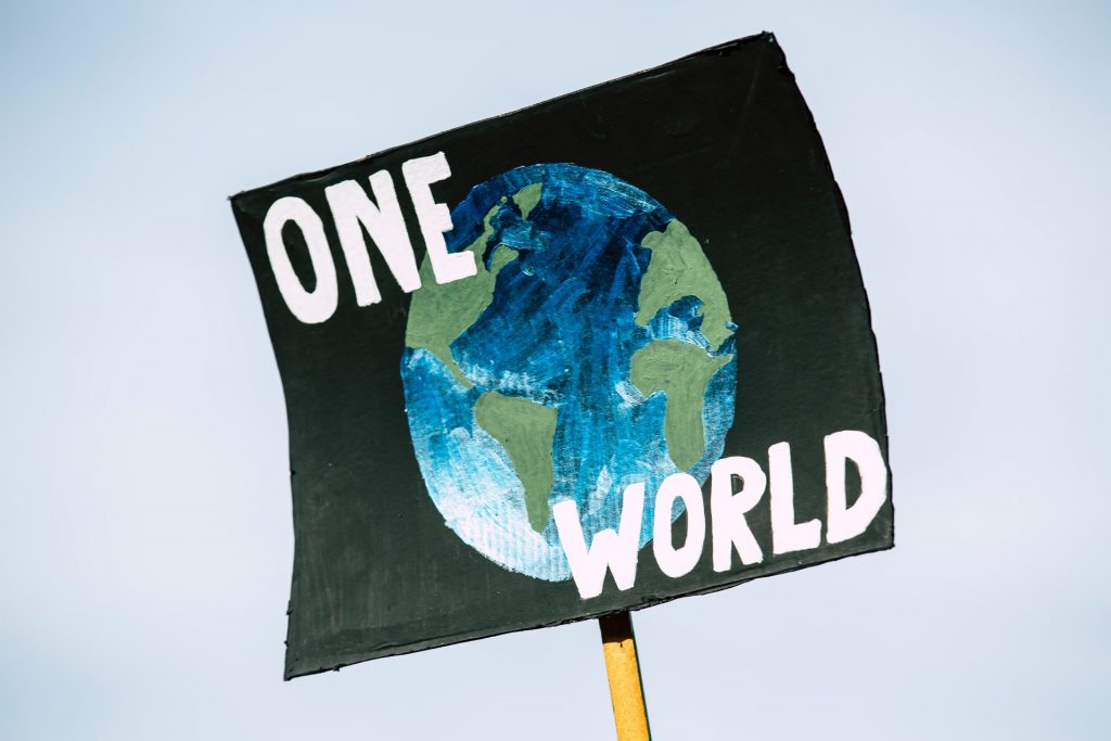 Cartel con el dibujo del mundo que pone "un mundo" en inglés