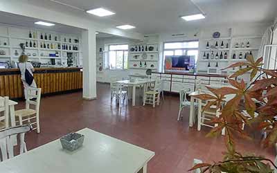 Cafetería amplia y luminosa con mobiliario blanco